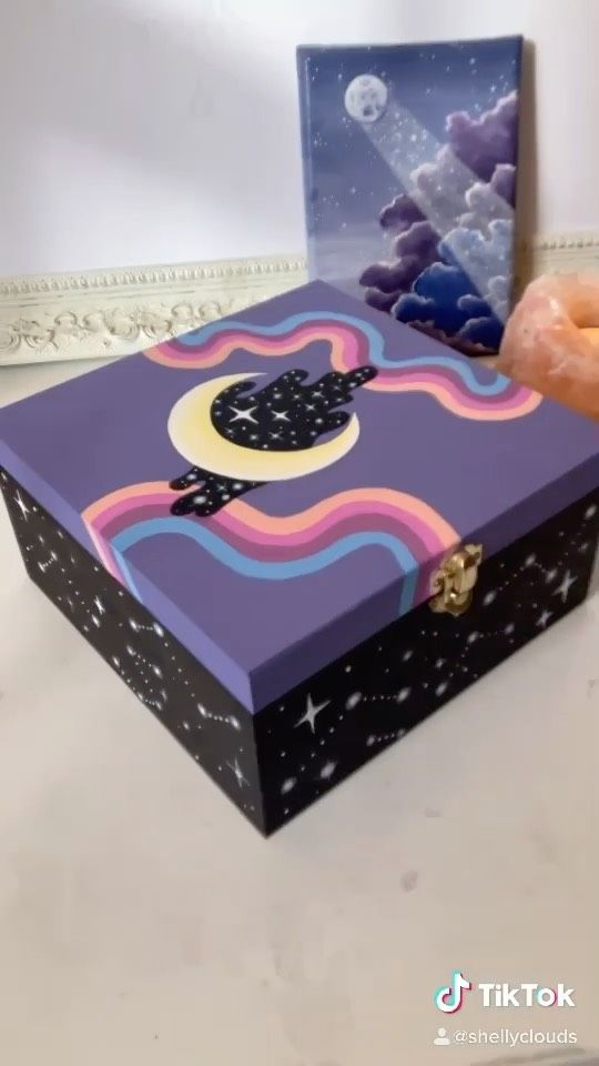 a hand is reaching into a purple box with an image of a cat on it