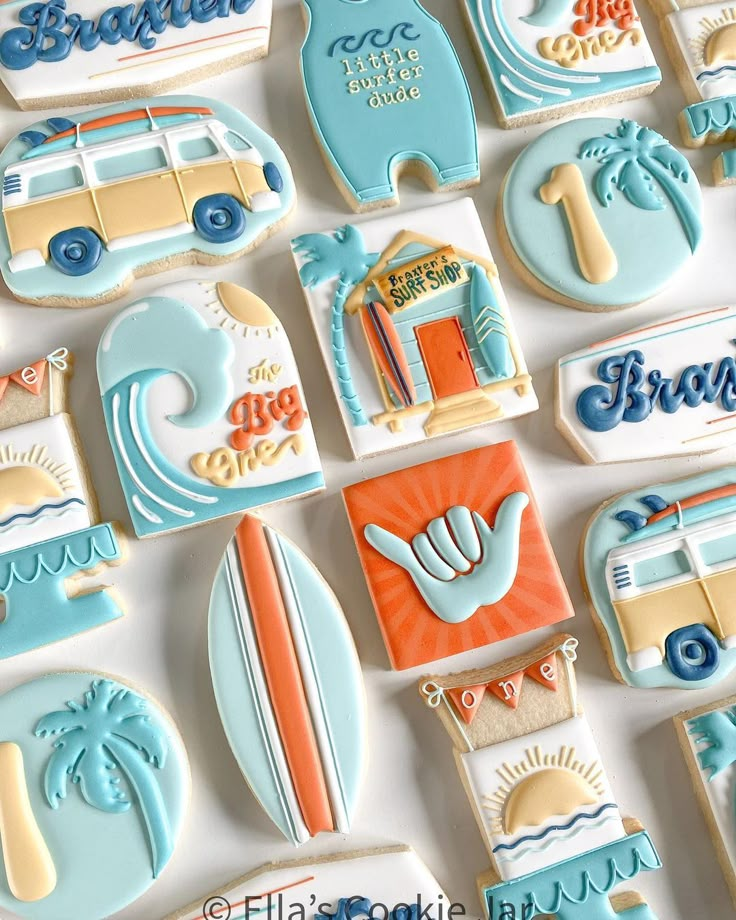 decorated cookies are arranged in the shape of boats, surfboards, and beach scenes