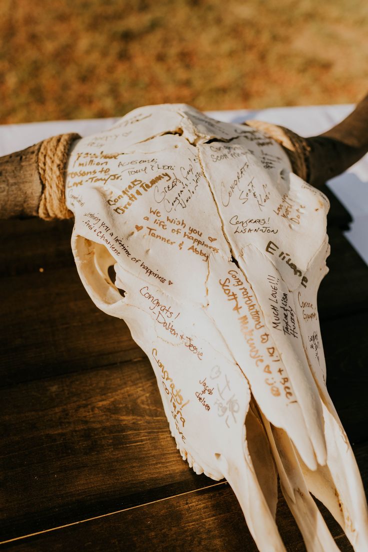 an animal's skull with writing on it sitting on top of a wooden table