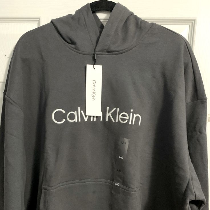 New With Tags Gray Calvin Klein Hooded Cotton Sweater Logo Print Hoodie For Fall, Calvin Klein Logo Print Sweatshirt For Fall, Casual Winter Hoodie With Logo Print, Calvin Klein Crew Neck Winter Sweatshirt, Calvin Klein Winter Sweatshirt With Ribbed Cuffs, Calvin Klein Crew Neck Sweatshirt For Winter, Calvin Klein Cotton Hoodie For Fall, Calvin Klein Hooded Sweatshirt For Fall, Calvin Klein Hooded Hoodie For Fall