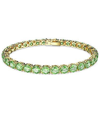 Embracing the contemporary fluidity of the Matrix Tennis family, this glittering bracelet surrounds your wrist in vibrant light-reflecting color. Round green stones are set in gold-tone plating in sleek uniformity, giving you a piece of jewelry that is striking enough to be worn alone, and simple enough to be styled with other pieces.Size: L Luxury Green Bracelet With Polished Finish, Swarovski Bracelet Gold, Luxury Green Tennis Bracelet For Formal Events, Luxury Green Tennis Bracelet, Green Bangle Tennis Bracelet For Formal Occasions, Luxury Green Round Tennis Bracelet, Elegant Green Tennis Bracelet For Party, Luxury Green Bracelets For May Birthstone, Green Formal Tennis Bangle Bracelet