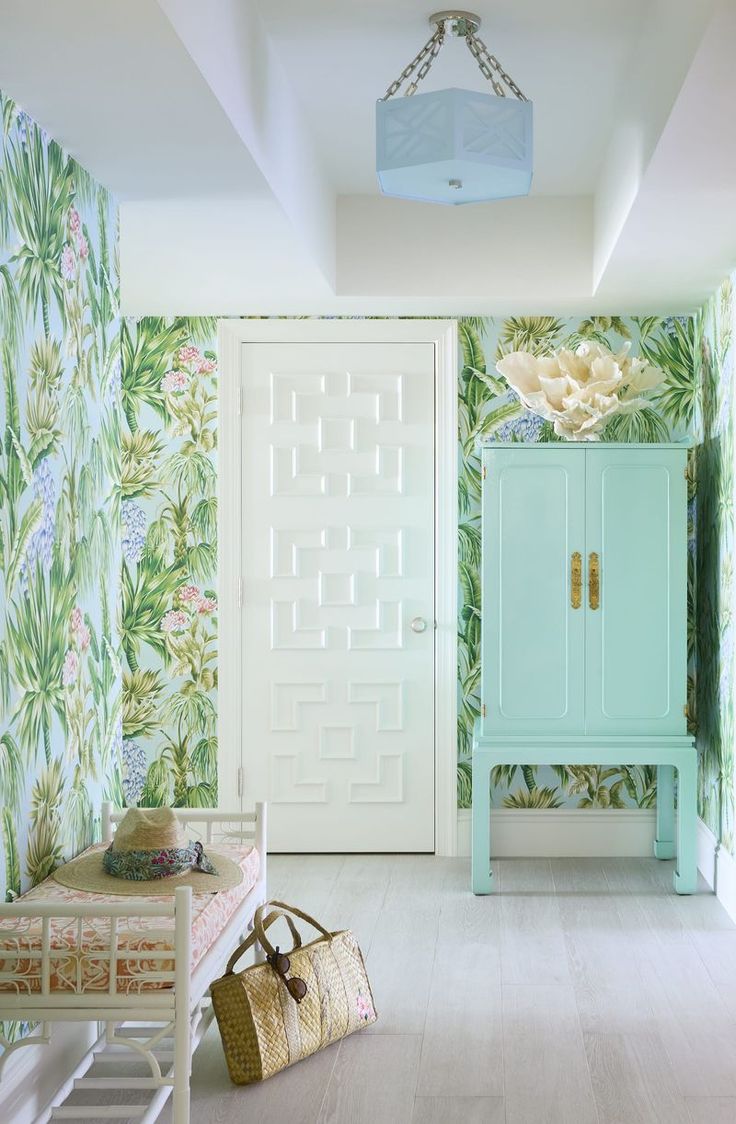 a blue cabinet sitting in the middle of a room next to a wallpapered wall