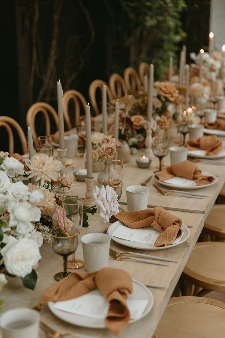 the table is set with candles, plates and napkins for an elegant dinner party