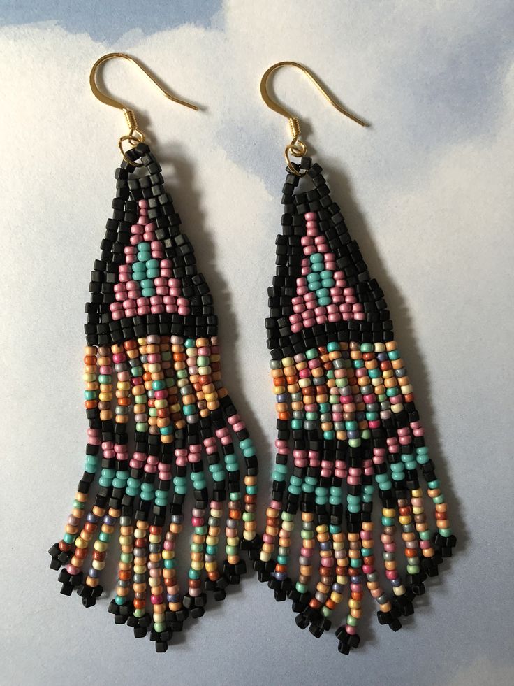 Stunning long metallic handmade seed earrings made with matte black square beads with pink, turquoise and soft matte pastel multicolored 11/0 seed beads. The earrings have long flowing fringe. The french hook earwires and findings are14kt gold plated. These gorgeous Cheyenne style earrings are super long and brush your shoulders ever so slightly. Great for daywear and stunningly beautiful for the night out. Earrings measure approximately 3-1/2 inches including ear wires. All items are handmade a Bohemian Black Beaded Dangle Jewelry, Beaded Fringe Long Drop Earrings For Festivals, Festival Beaded Fringe Long Drop Earrings, Bohemian Teardrop Beaded Earrings With Colorful Beads, Long Drop Beaded Fringe Earrings For Festivals, Festival Long Drop Beaded Fringe Earrings, Multicolor Beaded Bohemian Jewelry, Multicolor Teardrop Bohemian Jewelry, Bohemian Multicolor Teardrop Jewelry