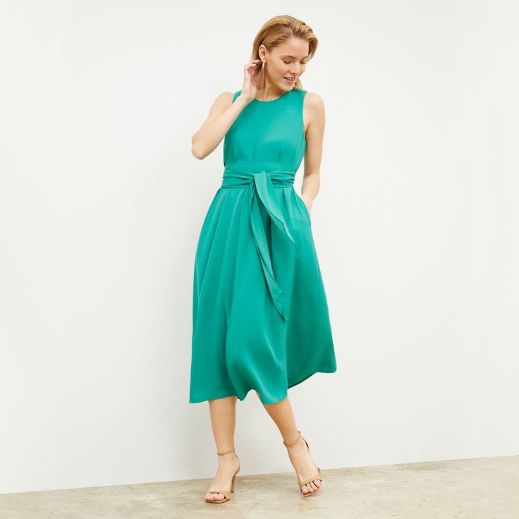 If a beautiful summer day were reincarnated as a piece of clothing, it would look like the Fatima dress. This elegant number features a relaxed fit, subtle A-line, and optional sash for your waist. This fabric is made from responsibly forested wood pulp and recycled polyester. Feminine Green A-line Midi Dress, Summer Daywear Belted Dresses, Breezy A-line Spring Dress, Summer Belted Dress For Daywear, Green Belted Midi Dress, Green Belted Midi Length Dresses, Flowy A-line Sleeveless Dress For Garden Party, Chic Green Belted Dress, Chic Flowy Midi Dress With Tie Waist