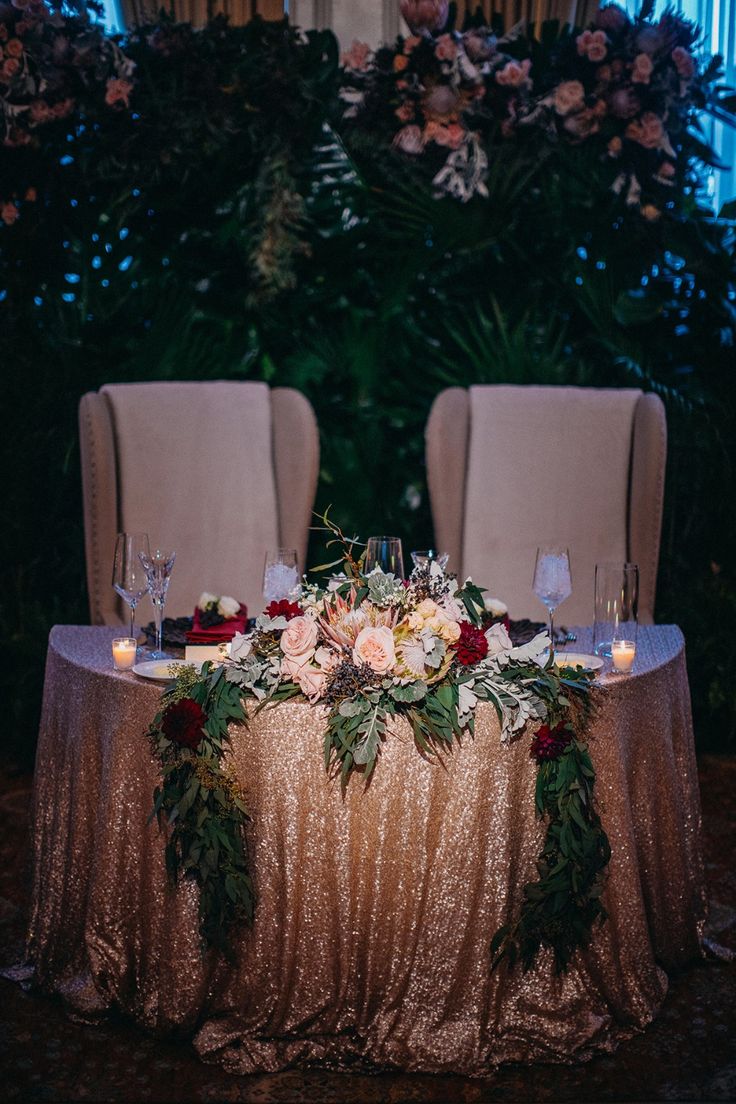 the table is set with candles, flowers and greenery for an elegant wedding reception