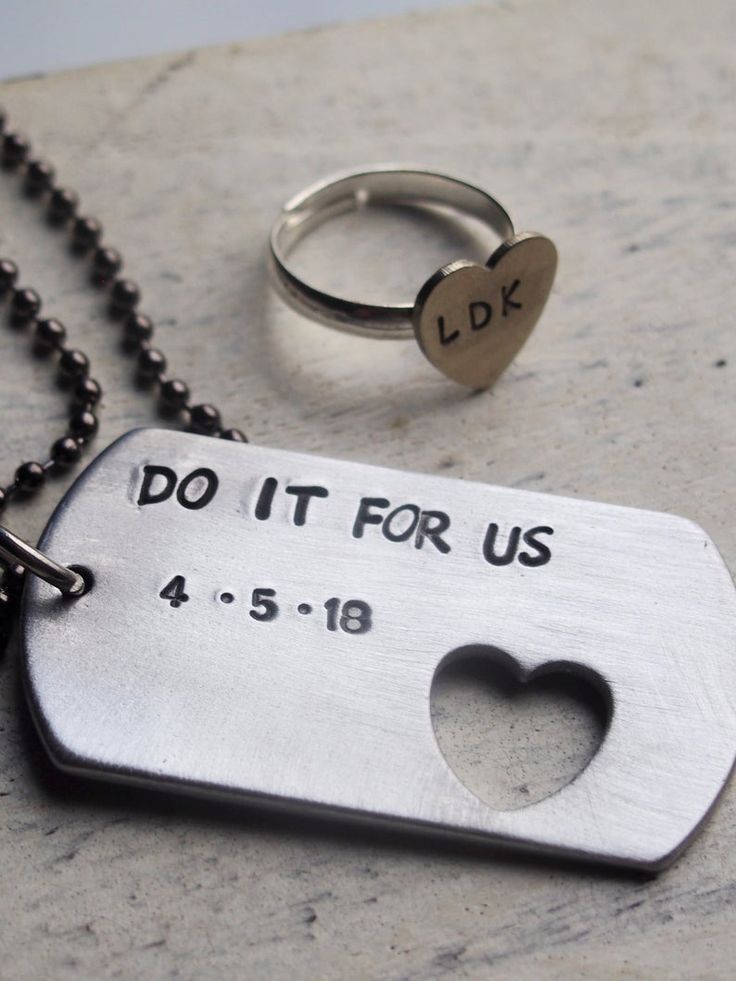 a couple of rings sitting on top of a table next to a heart shaped tag