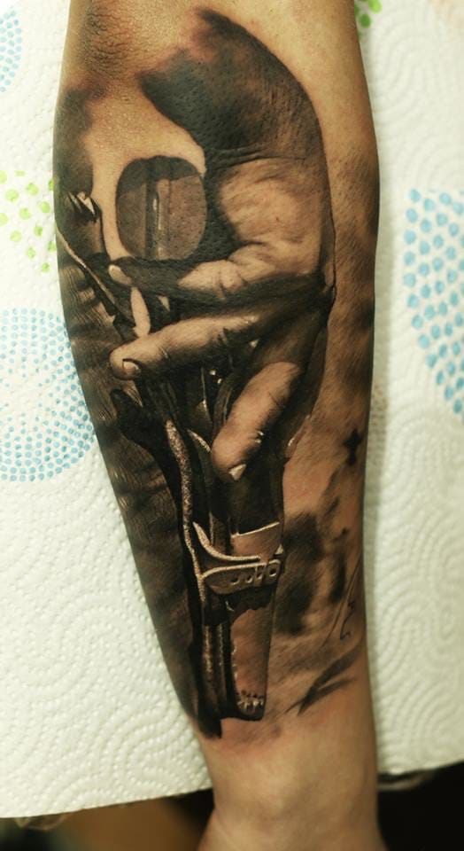 a man's arm with a tattoo on it that has an image of a hand holding