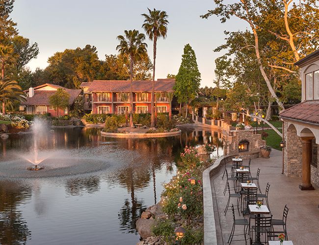 an outdoor dining area next to a pond