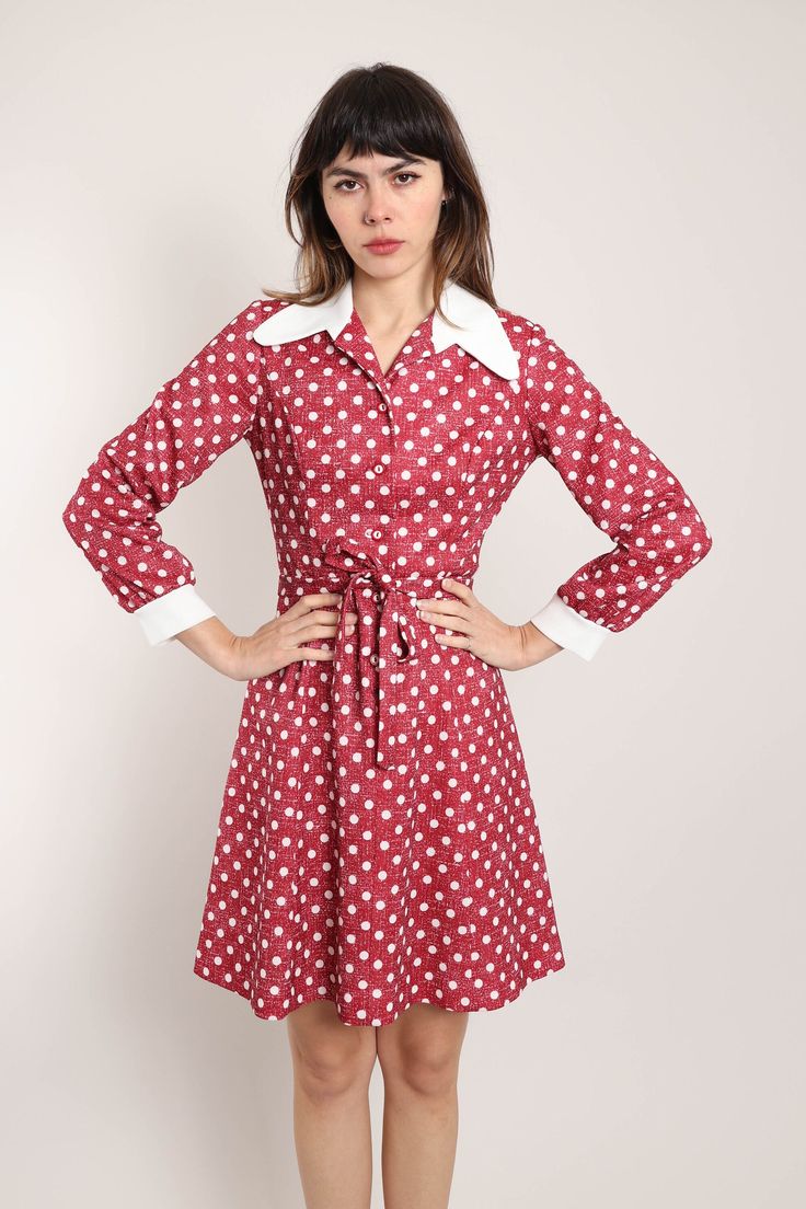 FEATURES - 1960s / 1970s dress - Maroon, white colors - Mod style - Polka dot print - Accent droop collar - Buttons up the front - Fitted waist - Matching tie at the waist for the perfect fit - Long sleeves with fitted cuffs - Flared mini length skirt CONDITION Excellent vintage condition: incredibly faint pea size mark on the left sleeve cuff. MEASUREMENTS & FIT suggested letter size: M (tag is marked a vintage women's US 12) shoulder: 15.25" bust (underarm): 36"-37" waist: 29"-31" hip: 42" length: 38" sleeve: 22.5" color: maroon, white material: polyester, buttons label: no label other than care and size tag pinned on model? no Note on fit: Fit was big. Adrianne is 5'10 33-25-36 with a modern dress size 2-4, letter size XS/S and a size 26 in jeans. All items are measured while the garmen White Retro Dress For Fall, Spring Polka Dot Collared Dresses, Vintage Doll Collar Mini Dress For Spring, Vintage Mini Dress With Doll Collar For Spring, Spring Vintage Mini Dress With Doll Collar, Vintage Fitted Mini Dress With Doll Collar, Fitted Retro Dress With Doll Collar, Retro Fitted Dress With Doll Collar, Retro Collared Mini Dress For Spring