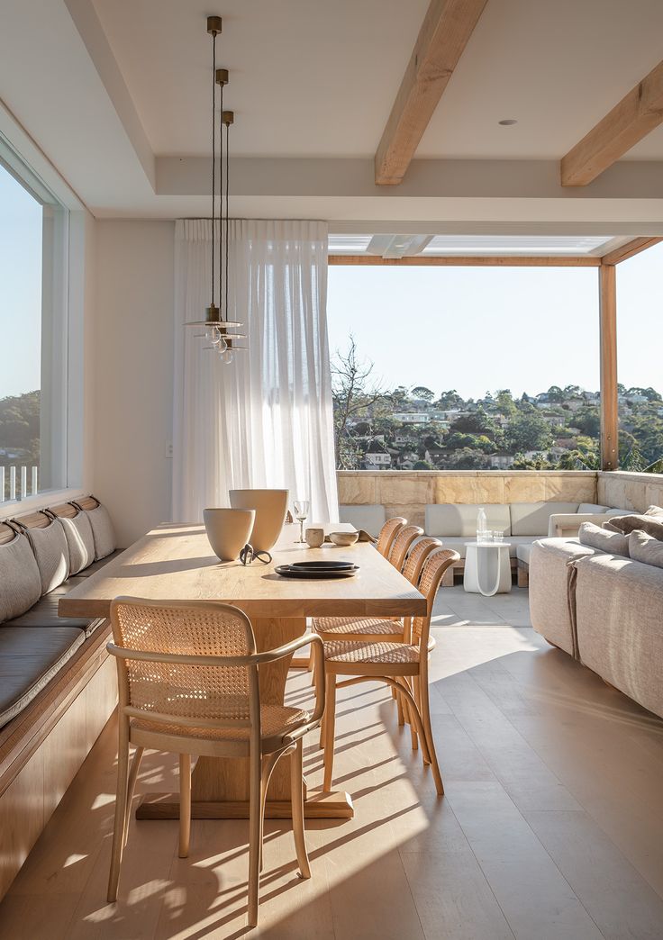 a table and chairs in a room with large windows