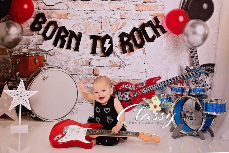 a baby is sitting in front of some guitars and other musical instruments, with the words born to rock above it