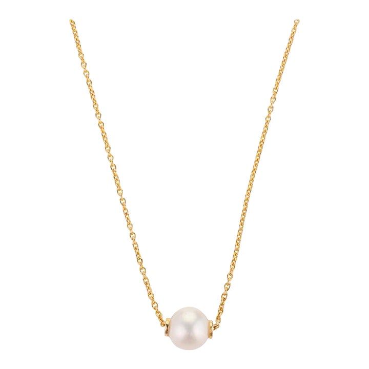 This is part of Chairish’s Fine Jewelry assortment.  Modern 5 Carat Single Pearl Chain Necklace in 18K Gold with round bead pearl. This stunning piece of jewelry instantly elevates a casual look or dressy outfit.  Pearl symbolizes purity, determination and perfection.  Designed with round pearl bead in a drill setting making a delicate necklace in solid gold settings. This is a perfect pearl necklace. It can be a Sisters Gift, Bridal Shower Gift, Valentine Gift, Gift For Sister, Mother Daughter Gift, Bride To Be Gift, Bridesmaid Gift, Grandma Gift, Gift For Girlfriend or any Holiday Gift for Mother, Sister, Daughter, Grandma, Fiancé, Girlfriend, Valentine, Family or Friend on your list.  PRODUCT DETAILS :-  Material - 18K Solid Yellow Gold Gemstone - Pearl Gemstone Weight - 5 cts Gemstone Classic Pearl Pendant Chain Necklace For Formal Events, Classic Cable Chain Necklace With Round Beads, Classic Round Pearl Necklace With Delicate Chain, Formal Pearl White Chain Necklace With Pearl Pendant, Elegant Beaded Pearl Chain Necklace, Classic Pearl Pendant Chain Necklace, Classic Chain Necklace With Pearl Charm For Formal Occasions, Classic Yellow Gold Pearl Chain Necklace, White Classic Pearl Necklace With Cable Chain