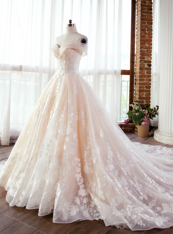 a wedding dress is displayed on a mannequin in front of a large window