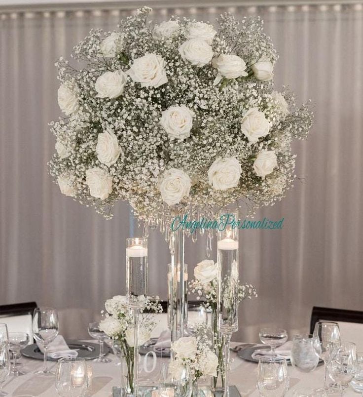 the centerpieces are filled with white flowers and baby's breath