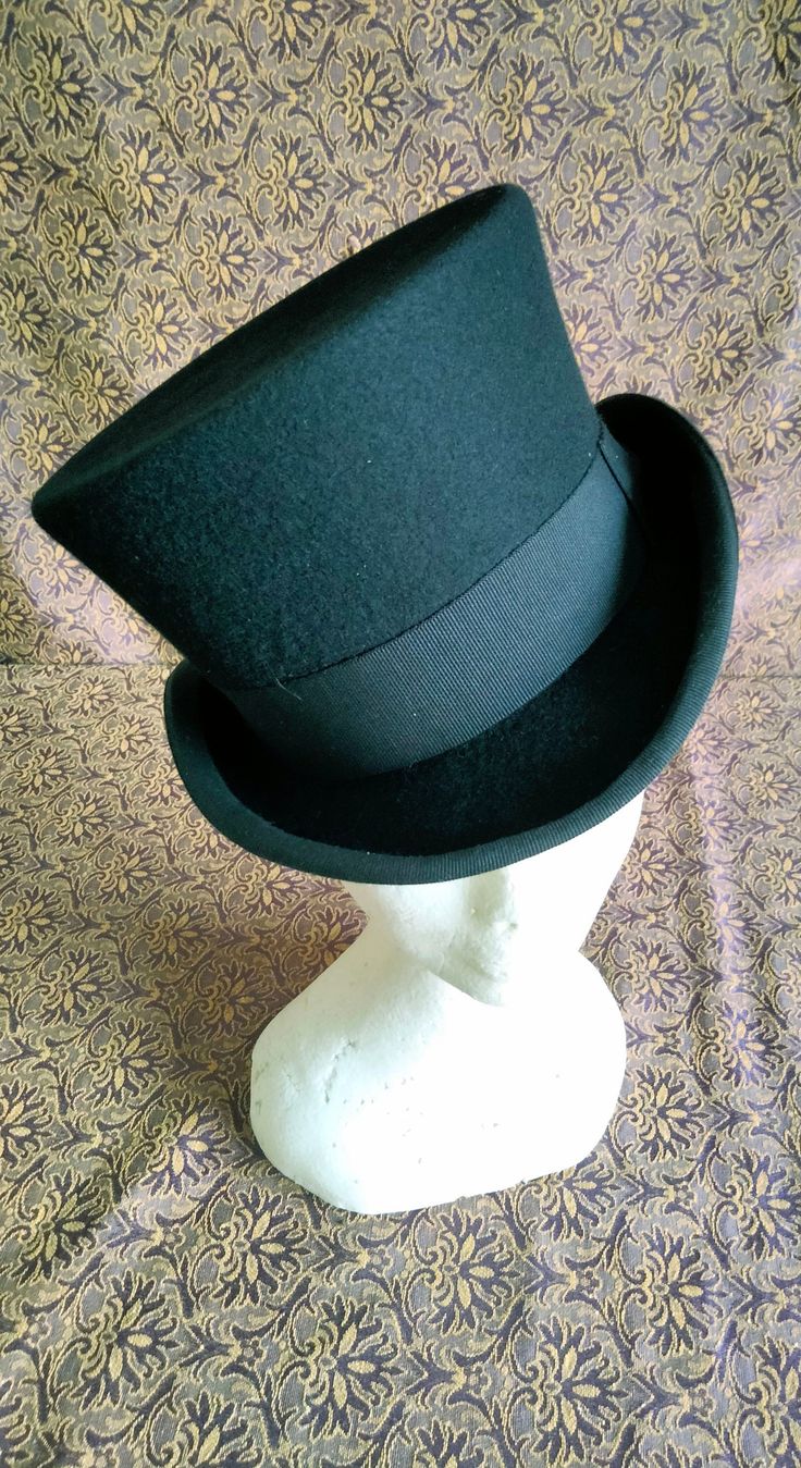 "Victorian style top hat in merinos wool, dome h 12 cm, brim 5 cm, outer band in black cotton h 4 cm, interior lined in white satin, internal sweatband in soft black leather. Entirely hand-made and sewn, the wing has the typical \"curl\" with the grosgrain finish sewn and turned used for the top hats and bowler hats of the 19th century." Classic Fedora Costume Hat For Winter, Classic Black Wide Brim Costume Hat, Curved Brim Formal Costume Hats For Winter, Classic Fitted Fedora Costume Hat, Formal Curved Brim Costume Hat For Winter, Formal Winter Costume Hat With Curved Brim, Classic Fitted Winter Costume Hats And Headpieces, Winter Formal Costume Hat With Curved Brim, Formal Black Costume Hats For Winter