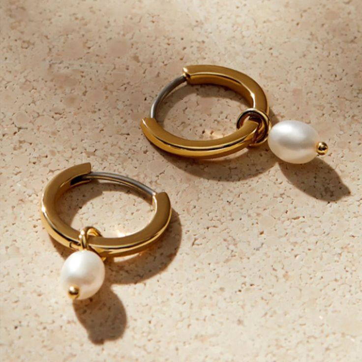 Elevate your style with our Chic Pearl Hoop Earrings. The fusion of pearls and hoops brings modern elegance to new heights. Adorn yourself with this sophisticated charm. Metal: 14K Gold Vermeil Length: 19.8 mm / 0.8" Hoop Diameter: 13.3 mm / 0.5" Thickness: 1.6 mm / 0.62" Gemstone: Pearl Weight: 0.8 g Modern Hoop Jewelry With Pearl Charm, Modern Hoop Earrings With Pearl Charm, Modern Small Hoop Earrings With Pearl Drop, Modern Small Hoop Pearl Drop Earrings, Modern Gold Hoop Earrings With Pearl Charm, Modern Yellow Gold Hoop Pearl Earrings, Modern Yellow Gold Pearl Hoop Earrings, Modern Yellow Gold Hoop Earrings With Pearl Drop, Types Of Buttons