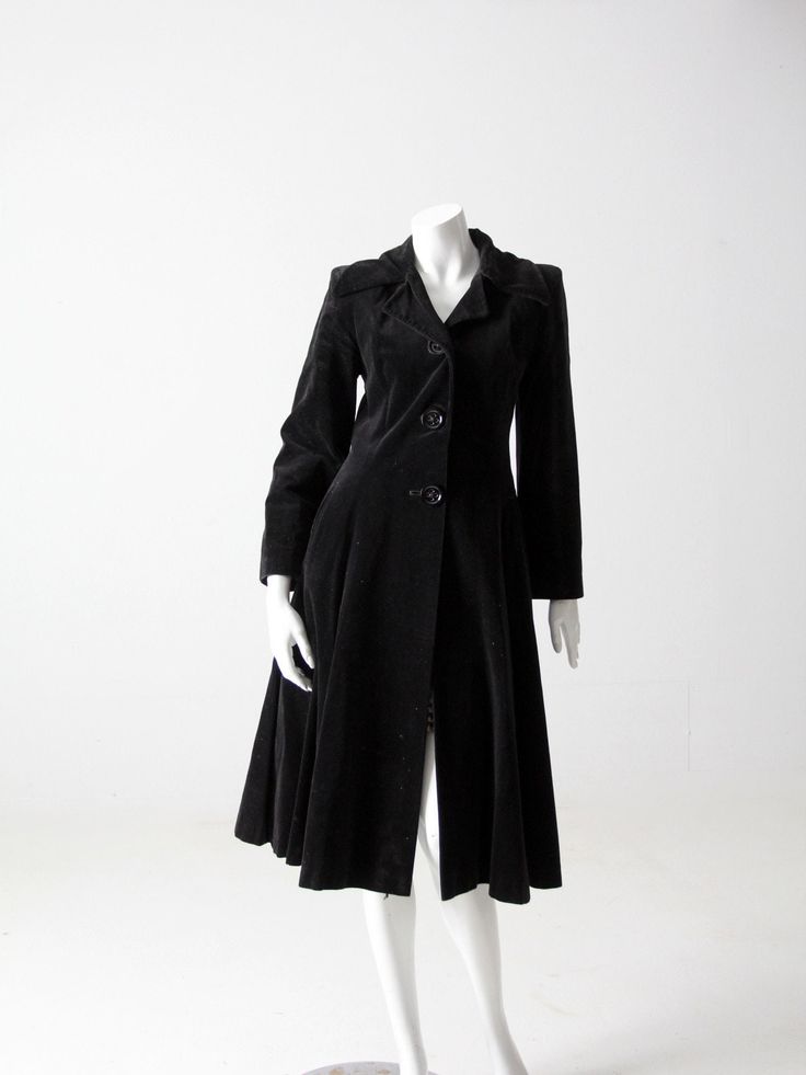 This is a late 1960s Stirling Cooper coat when they took a partnership with the tailoring company, Sheraton.  A stunning, black velvet fitted dress coat.  Dynamic styling with a full skirt, fitted bodice, and three oversize button closures.  Fully lined.  CONDITION In good condition with wear consistent with age and use.  Some light wear to the nap of the velvet in spots (primarily at the elbows). APPROXIMATE FIT:  S MEASUREMENTS Bust:  34"  .. 86.4 cm Waist:  28"  ...  71.1 cm Shoulders:  15.5"  ..  39.4 cm Length:  43"  ..  109.2 cm Outside Sleeve:  22.5"  ..  57.2 cm 883872 Fitted Velvet Outerwear For Winter, Vintage Long Coat For Party, 1950s Style Fitted Winter Outerwear, 1950s Fitted Winter Outerwear, 1950s Formal Fall Outerwear, Fitted Velvet Outerwear With Button Closure, Elegant Fitted Outerwear For Vintage Fashion, Fitted Long Outerwear For Evening, Elegant Fitted Vintage Fashion Outerwear