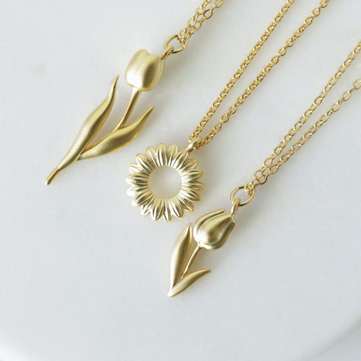 "Beautiful and lovely gold Tulip charm necklace. Made of a matte gold finish Tulip charm with a skinny gold plated brass chain. Soft and simple. Great for gift, everyday or special occasion. Your item will ship in a gift box. Please feel free to contact me if you have any questions. ♥ Length 14\" - 20\" chain ♥ Tulip charm 3/8\" x 5/8\" long ♥ Gold plated over brass ♥ See more Rudiana Accessories Rudiana.etsy.com" Gold Flower Necklace For Everyday Wear, Gold Flower Charm Necklaces For Everyday, Gold Flower Charm Necklace For Mother's Day, Everyday Gold Charm Necklaces With Flower Charm, Mother's Day Gold Charm Necklace With Flower Charm, Mother's Day Gold Charm Necklace With Flower, Mother's Day Gold Necklace With Flower Charm, Mother's Day Gold Flower Charm Necklace, Gold Brass Necklaces For Mother's Day