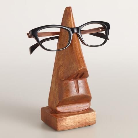 a wooden sculpture with glasses on it's head and an eyeglass holder in the shape of a man