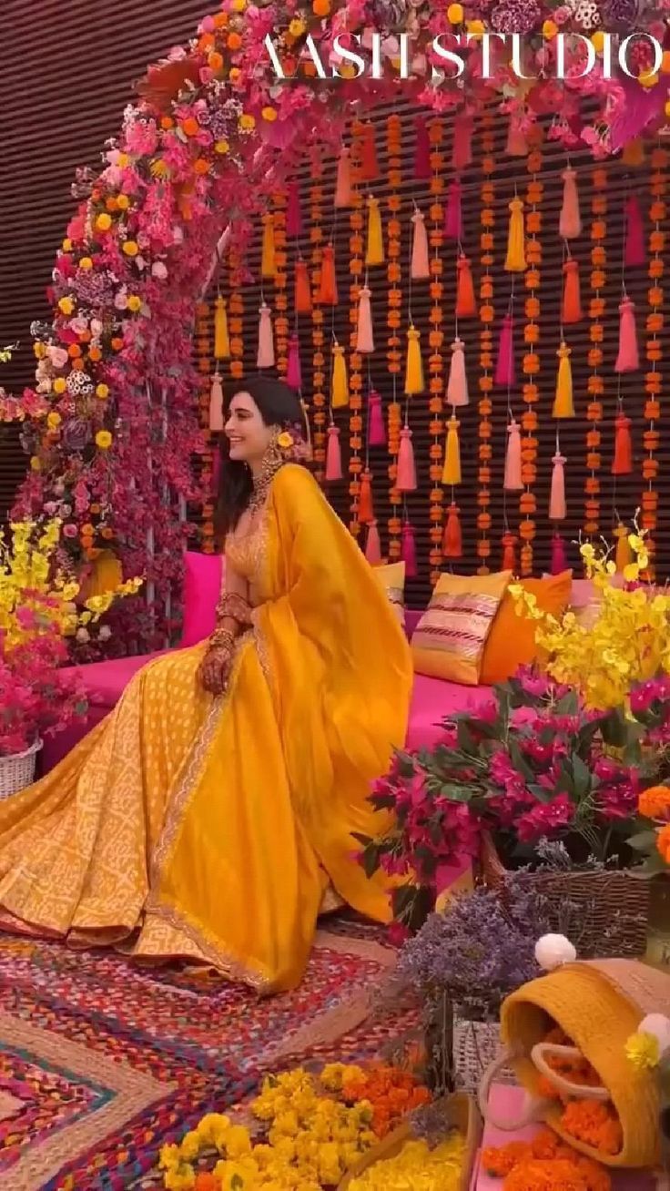 a woman sitting in front of a display of flowers