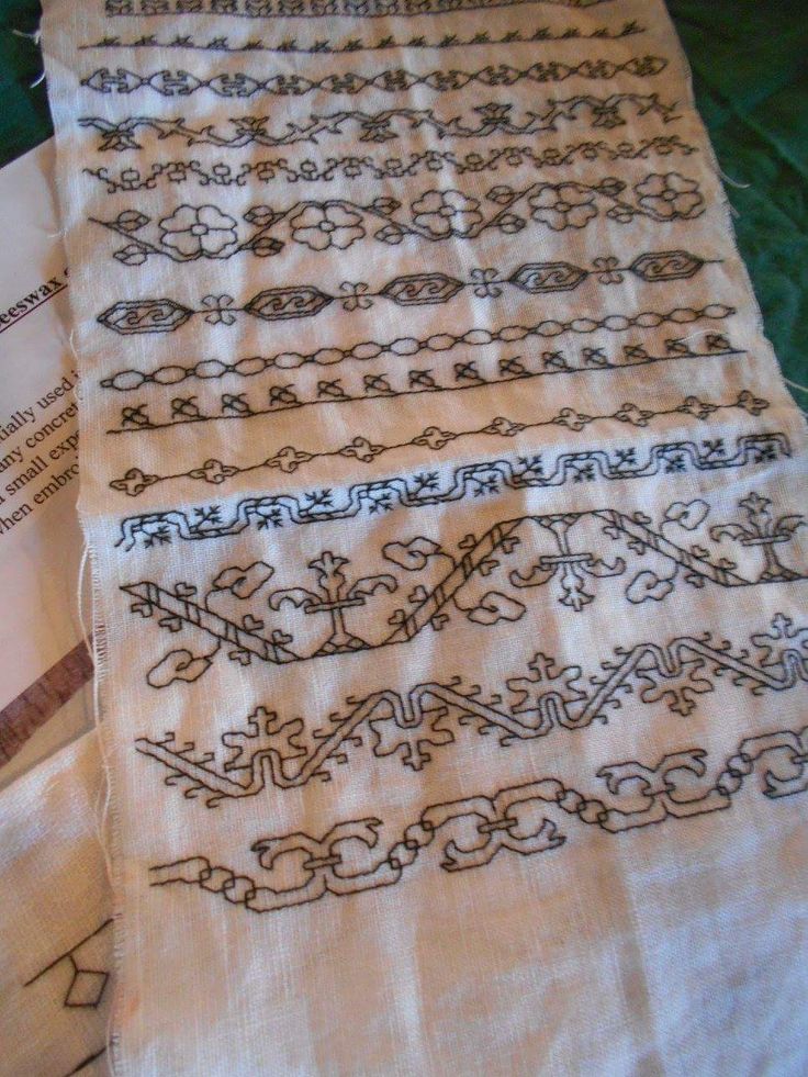 two pieces of cloth with designs on them sitting next to each other and one piece has been stitched