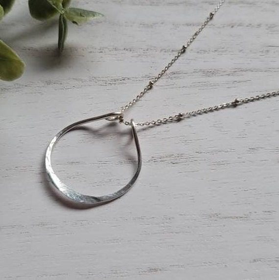 "Ring Holder Pendant Necklace, Minimalist, Functional, Gift for Wife, Wedding, Engagement, Nurse, Gift For Her | © Each design is completely designed and handcrafted in our traveling studio. Our delicate selection of chains completes our dainty design but it also provides a strong durable piece. Perfect for the newly engaged bride, a new mom, or a nurse in your life! Our modern, minimalist moon pendant is not only trendy, but it is also functional, it helps your loved one keep one of the most pr Ring Necklace Holder, Wedding Ring Necklace Holder, Wedding Ring Necklace, Jewelry Metalsmithing, Ring Holder Pendant, Engagement Ring Holders, Ring Holder Necklace, Personalized Family Gifts, Diy Jewlery