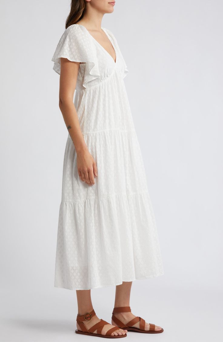 This ever-enchanting cotton maxi is designed with fluttering sleeves and a flouncy tiered skirt. 50" length (size 8) Adjustable back tie closure V-neck Short sleeves Lined 100% cotton Machine wash, tumble dry Imported White Flutter Sleeve Beach Dress, White Flutter Sleeve Playtime Dress, White Short Sleeve Feminine Tiered Dress, Casual White V-neck Tiered Dress, White Cotton T-shirt With Flutter Sleeves, Cotton Maxi, Tier Skirt, Maxi Dress With Sleeves, Nordstrom Dresses