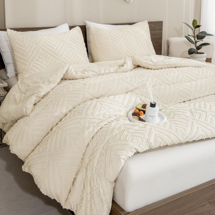 a bed with white comforter and pillows on it