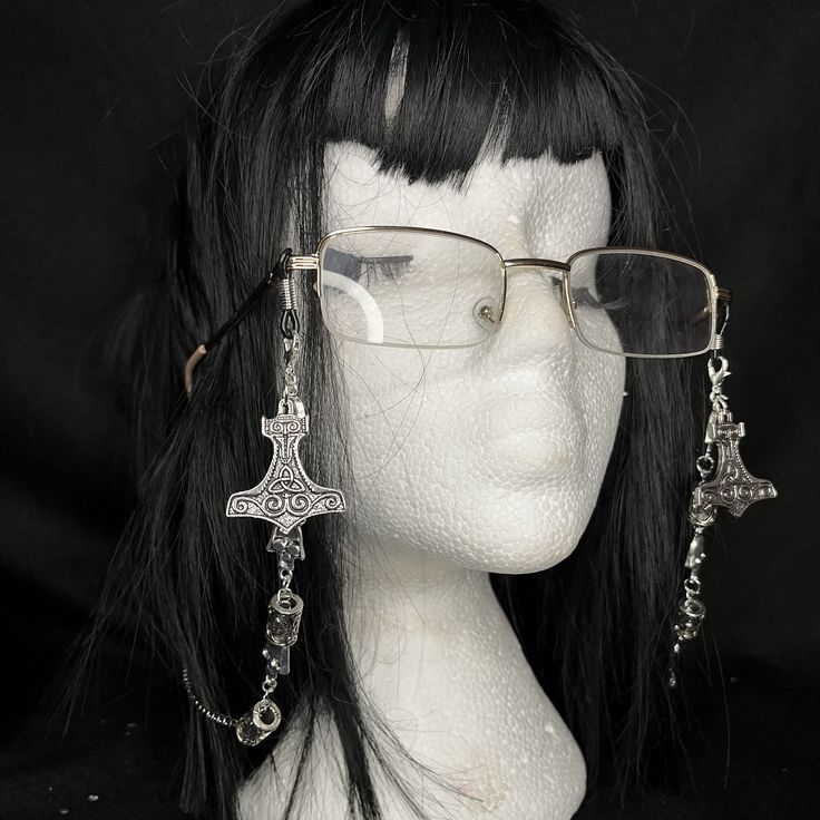 Thor glasses chain Brand new! Jazz up those spectacles with these beautiful chains. Unisex item. Adorned with skulls and runes on a stainless steel chain with hanging thor hammers. Suitable for all glasses types. The elastic loops fit comfortably on your frames without causing damage. Wear them near the front to make a statement or further back on your frames to appear like earrings.  Never lose your glasses again as this makes it easier to wear your glasses around your neck or even ontop of you Handmade Silver Glasses Chains For Festival, Vampire Glasses, Glasses Alternative Style, Chain Glasses Aesthetic, Glasses Accessories Chain, Silver Glass Glasses Chains For Festival, Glasses With Chain Aesthetic, Goth With Glasses, Glasses With Chain