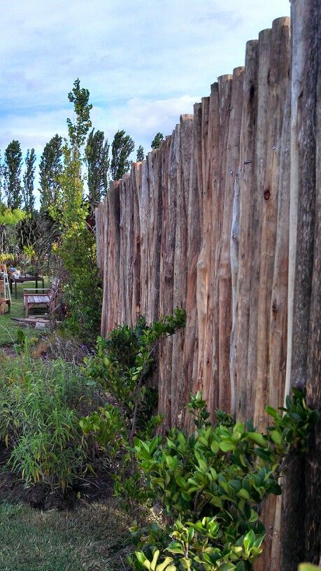 a wooden fence in the middle of a grassy area