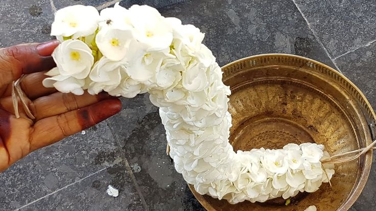 a person is holding flowers in a bowl