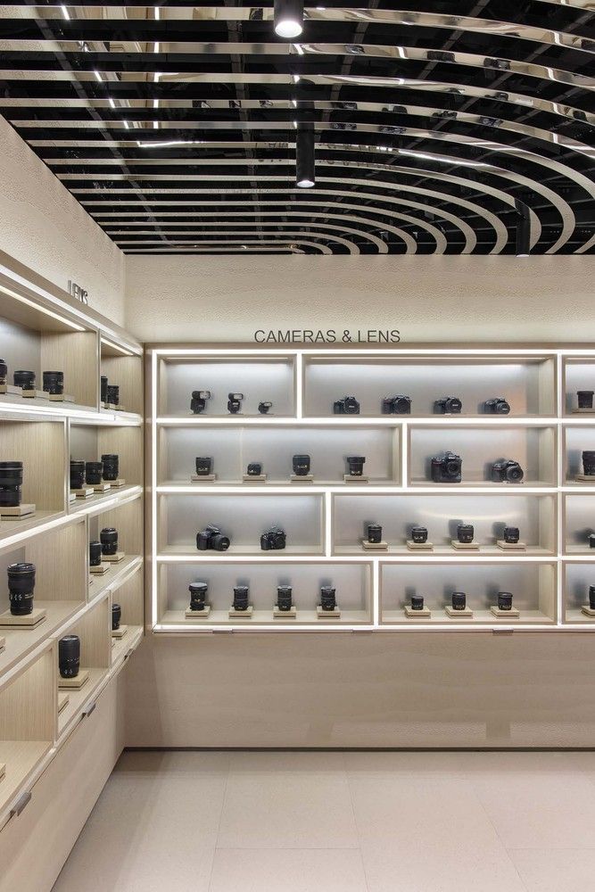 a room filled with lots of white shelves covered in glass cases and black cups on top of each shelf