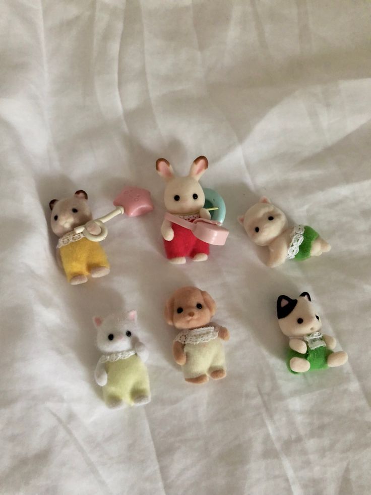 small toy animals are arranged on a white sheet