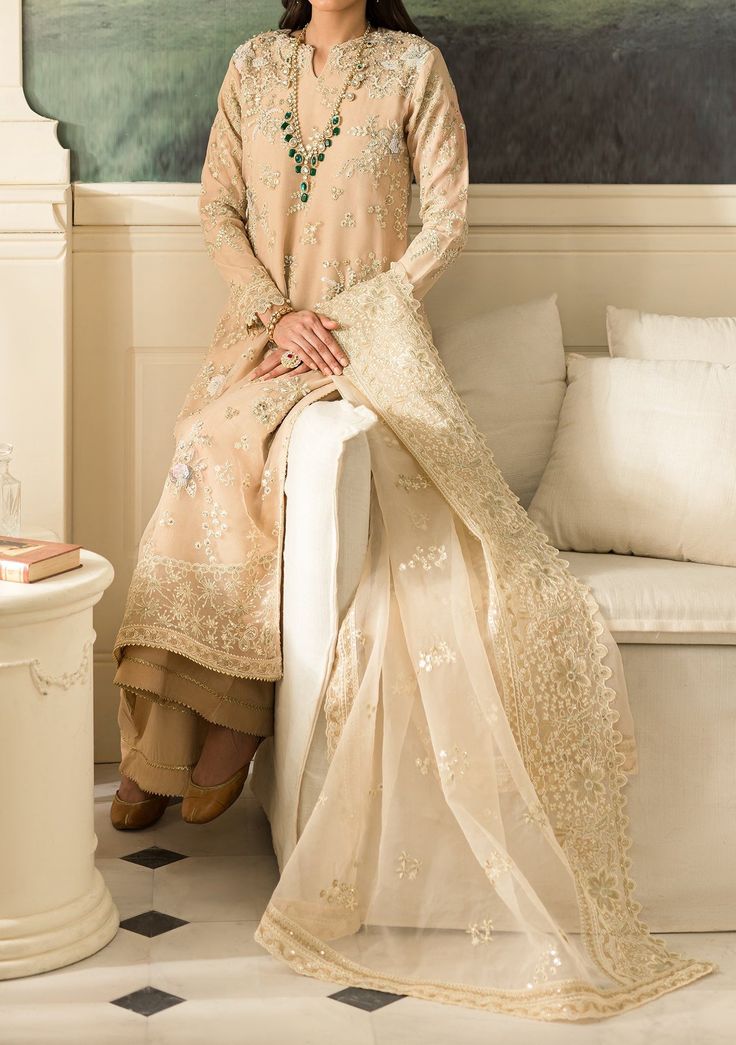 Introducing our latest collection 'SUAVE LUXURY FORMALS' by Emaan Adeel designed to make you look and feel your best these pieces will add a touch of class and elegance to your wardrobe. This collection is a beautiful collection of ensembles offering versatile compositions for the latest festive wardrobe requirements. Organza Embroidered Hand Made Neck Line. Organza Embroidered Hand Made Front. Organza Embroidered Back and Sleeves. Organza Embroidered Dupatta. Organza Embroidered Front, Back, and Sleeves Border. Organza Embroidered Back Patch. Dyed Raw Silk Trouser. Color: There might be slight color variation due to lighting and flashes while the photo shooting. The color may also vary because of different screen resolutions. Wash Care: Dry Clean Only. Unstitched Silk Dress With Intricate Embroidery, Traditional Beige Dresses For Eid, Beige Zari Work Wedding Dress, Beige Zari Wedding Dress, Beige Wedding Dress With Zari Work, Beige Resham Embroidered Wedding Dress, Beige Resham Embroidery Wedding Dress, Traditional Beige Dress For Festive Occasions, Straight Kurta Dress In Organza With Intricate Embroidery