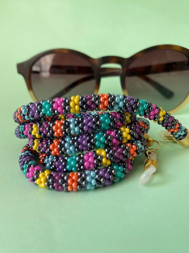 The perfect accessory for your wardrobe, adding a finishing touch to your outfit. Multi-functional glasses, sunglasses and mask chain holder with multi-colored beads. It can also be used as a necklace. Thank you in advance for choosing my designbycolla store. If you have a question, I can answer immediately. My three-functional product, which can be eyeglass chain, necklace, bracelet, is completely made with the help of handmade crochet. This eyeglass chain can be a very perfect choice for your Resizable Multicolor Jewelry Fashion Accessory, Resizable Multicolor Jewelry For Fashion, Trendy Multicolor Glasses Chains, Beaded Glasses Chains With Round Beads, Colorful Beads Glasses Chains As Summer Gift, Summer Glasses Chains With Colorful Beads As Gift, Handmade Adjustable Glasses Chains With Round Beads, Multicolor Adjustable Chain Glasses Chains For Fashion, Trendy Multicolor Glass Beaded Necklaces