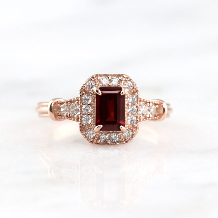 Gorgeous Vintage Inspired Garnet Ring ►Made of solid sterling silver with the 14k rose gold finish (925) ►Accented With Simulated Diamonds (CZ) ►Average band width: 2.3 mm ►Halo size: 9.9mm x 8.3mm Center Stone: Garnet Stone Cut: Emerald Measurements: 4.0 x 6.0 mm Carat Weight: 0.7 ct. (approx.) Gemstone creation: 100% Natural Hardness: 7.5 (Mohs scale) ►Average band width: 1.6 mm ►Please be aware that plated jewelry can wear off over time, if this is a concern we would suggest going with the st Classic 14k Rose Gold Ruby Ring For Anniversary, Classic 14k Rose Gold Rings With Accent Stones, Classic Rose Gold Ruby Ring For Anniversary, Classic Rose Gold Ruby Promise Ring, Classic Rose Gold Ruby Ring For Proposal, Classic Rose Gold Ruby Ring, Classic Ruby Ring In 14k Rose Gold, Classic Red Jewelry In 14k Rose Gold, Classic Red 14k Rose Gold Jewelry