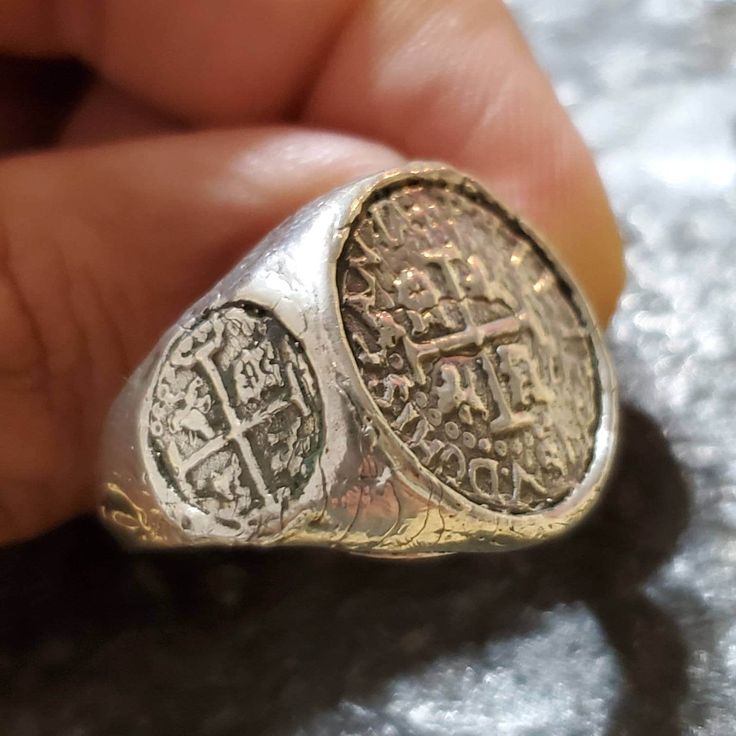 This coin ring has a very rough,  and antique finish to give it an old world feel. It's solid sterling silver, and there is a main center coin,  and a small coin on each side that gives this piece a very unique setting. The coins themselves are made from the silver bars recovered from the Atocha and comes with a certificate stating that. Antique Coin-shape Engraved Signet Ring, Antique Coin Shaped Engraved Signet Ring, Antique Engraved Coin Signet Ring, Vintage Engraved Coin Signet Ring, Treasure Coin, Key West Fl, Old Rings, Coin Ring, Ring Antique