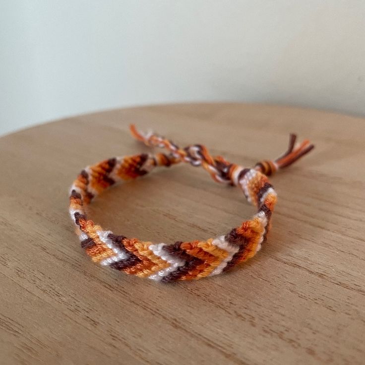 an orange and white bracelet on top of a wooden table