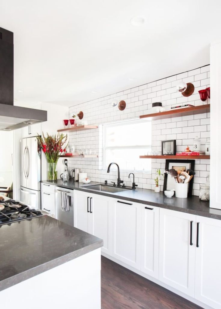 a kitchen with white cabinets and black counter tops is seen in this image from the front view