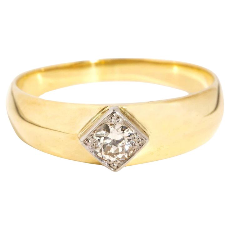 a yellow gold ring with a diamond set in the center, on a white background