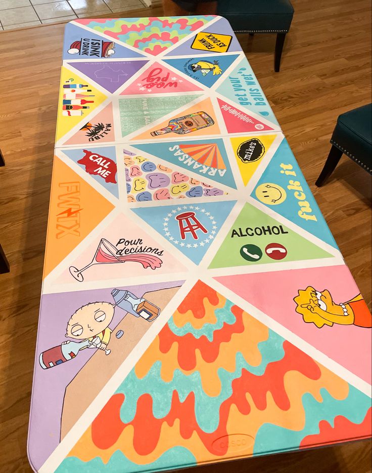 a long table covered in colorful stickers on top of a hard wood floored room