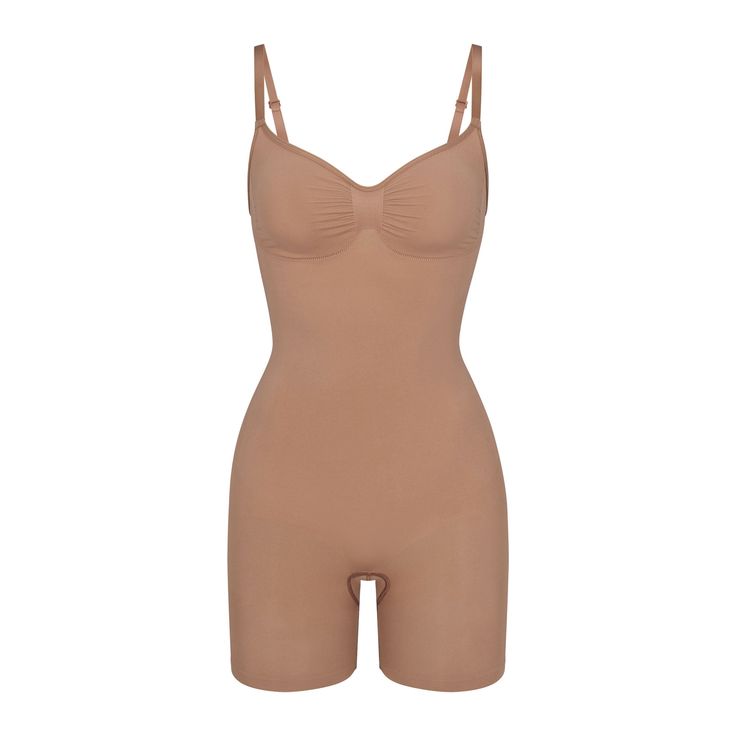 The sculpting bodysuit all over your feed, updated for an even better fit. Wear this mid thigh bodysuit for strong compression and targeted control along the waist, tummy, and legs, plus butt-enhancing pockets for a lifted look. Features front pique stitching along the front and sides for a defined and supported bust, adjustable straps, a wide crotch for added coverage, and a cotton gusset. Fits true to size. | SKIMS Mid Thigh Bodysuit | Medium Neutral | Seamless Sculpt Tshirt Bodysuit, Sculpting Bodysuit, Plunge Bodysuit, Strapless Bodysuit, High Neck Bodysuit, Mock Neck Bodysuit, Blue Bodysuit, Sheer Bodysuit, Cami Bodysuit