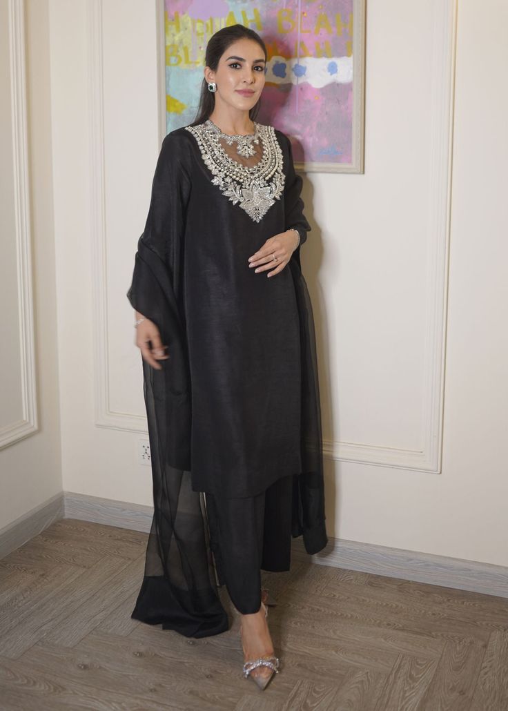 Black raw silk dress has beautiful sequin and cutdana embroidery over the neck, paired with orgenza dupatta. This dress is fully lined. ✨ You can wear this super stylish dress in any of your party, office and gathering ✨This dress can be customise in any other colour and in all size also ,please contact us regarding any changes if you want.We will make this dress as per your choice. ✨We take little longer time to manufacture as we take lot of care while manufacturing the outfit. So that our customers get fully satisfied when they receive the dress. Your patience is important ✨There may be slight colour difference due to high quality camera resolution and other filters. Rest everything will be same.  🌸Care instructions Dry clean only Long Sleeve Organza Salwar Kameez With Mirror Work, Elegant Organza Sharara With Mirror Work, Chanderi Dabka Palazzo Set For Party, Elegant Chanderi Dresses With Dabka Detailing, Tissue Silk Palazzo Set For Eid Party, Formal Sets With Mirror Work And Straight Kurta, Elegant Churidar With Dabka In Chanderi, Designer Elegant Churidar With Dupatta, Elegant Chanderi Churidar With Dabka Details