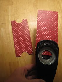 two pieces of red paper with white polka dots on them are being held by a hand