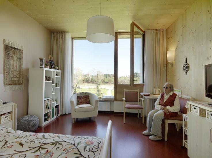 an elderly woman sitting in her living room watching tv