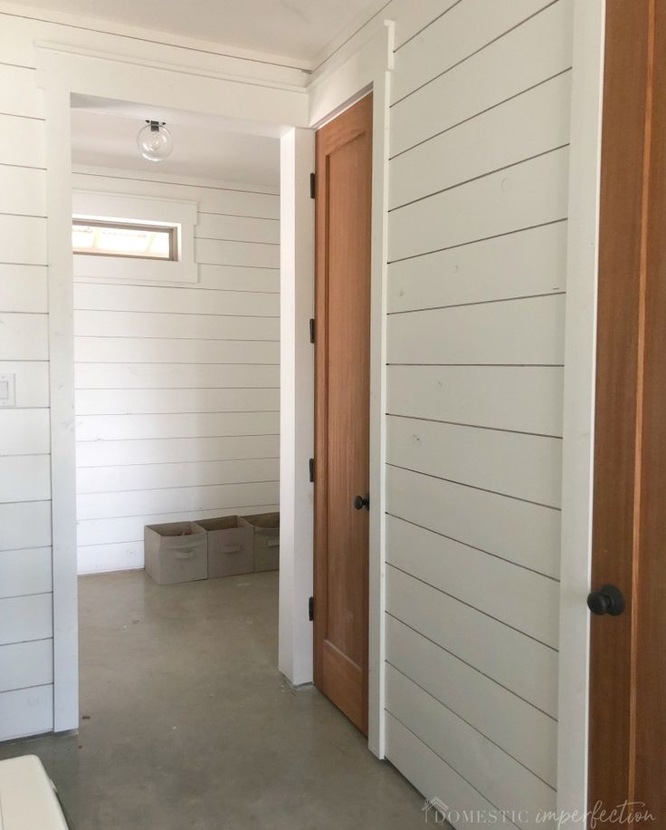 an empty room with white walls and wood door frames on either side of the doorway