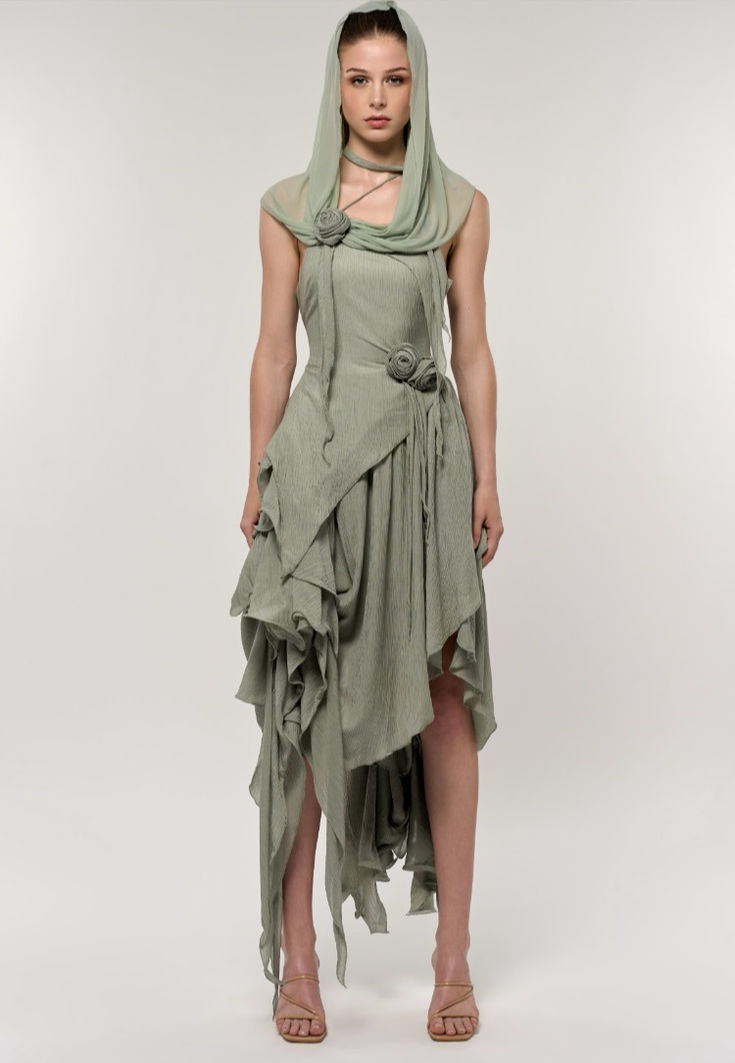 This set includes a sleeveless, fitted bodicean top and an asymmetrical skirt, featuring cascading ruffles in the same seafoam green ribbed fabric. The crisp and enchanting green, filled with vibrant vitality, evokes the sense of everything springing back to life and flourishing. These ruffles add volume and create a flowing, dynamic look as they unevenly descend to varying lengths around the skirt, with some layers reaching down to the ankle. Fitted Green Dress With Asymmetrical Hem, Green Fitted Dress With Asymmetrical Hem, Green Fitted Asymmetrical Dress, Green Fitted Sleeveless Asymmetrical Dress, Green Asymmetrical Neckline Pre-draped Dress, Fitted Asymmetrical Ruffle Dress, Green Asymmetrical Ruched Dress, Sage Fitted Sleeveless Dress, Sage Sleeveless Fitted Dress