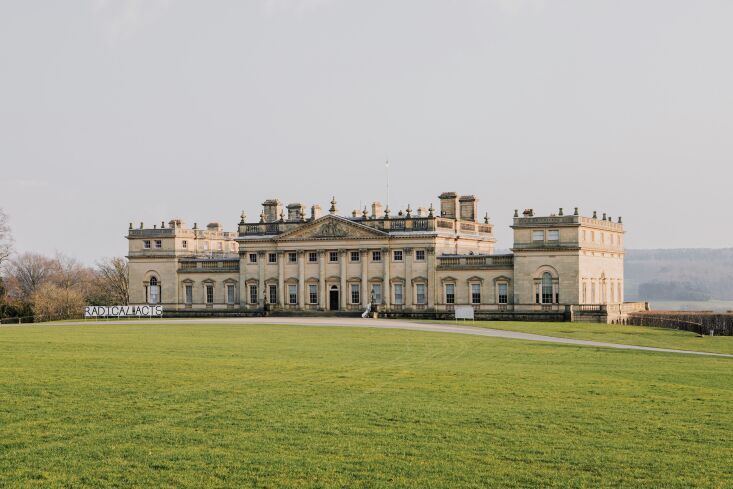 a large building sitting on top of a lush green field