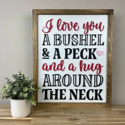 a sign that says i love you, a bushell and a peck and a hug around the neck